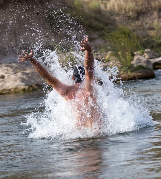 Een man springt uit het water — Stockfoto