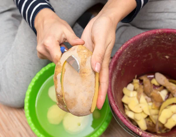 Женщина чистит картошку — стоковое фото