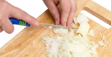 beyaz zemin üzerinde bir gemide Cook soğan kesmek