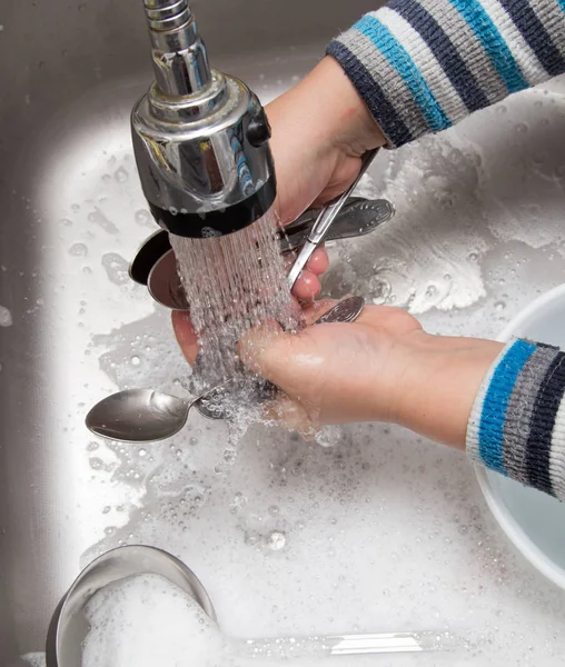 Boy washing dishes in the kitchen — Stock Photo, Image