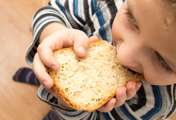 Junge isst Brot — Stockfoto