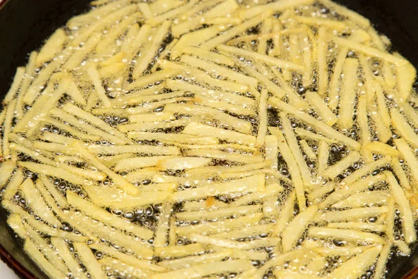 Cooking potato fries in oil — Stock Photo, Image