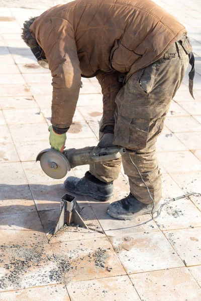 Arbetaren klipper metall i parken — Stockfoto