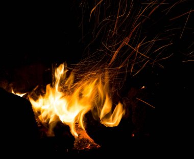 Siyah arkaplanda kıvılcımlar saçan ateş