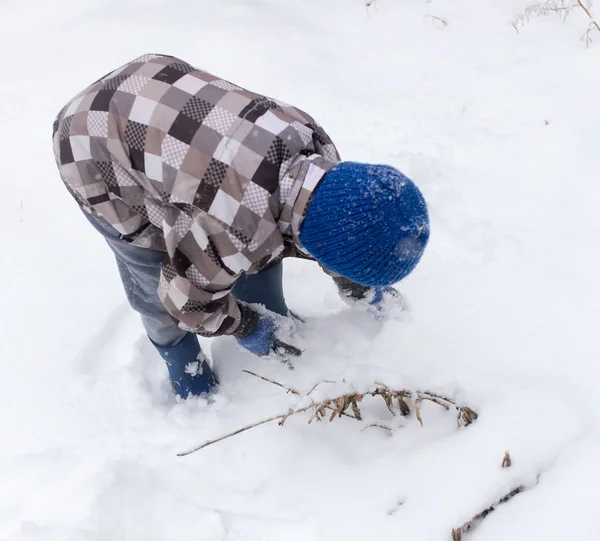 Garçon jouer avec la neige en hiver — Photo