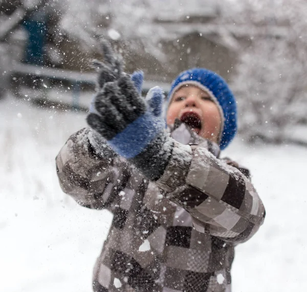 Garçon jouer avec la neige en hiver — Photo