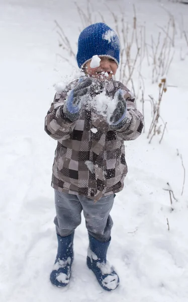 Boy playing with snow in winter — Stock Photo, Image
