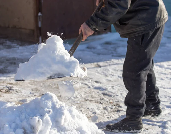 Worker cleans snow shovel — Stock Photo, Image
