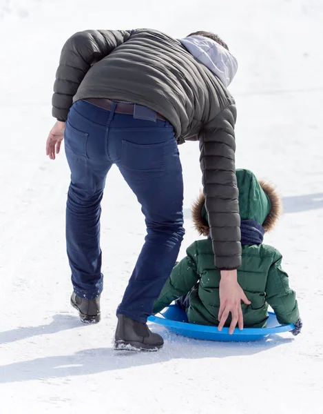 Baba çocuk bir kızak üzerinde rulo.