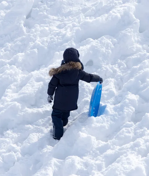 Enfant chevauchant un montagnes russes en hiver — Photo