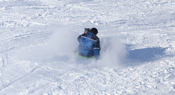 Dad rolls the child on a sled