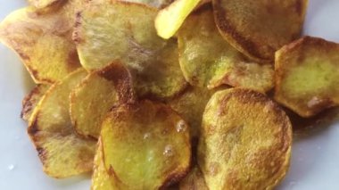 Ev yapımı patates cipslerinin yağlı tavada yakın çekim görüntüleri.