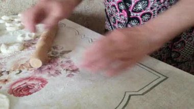 Olgun bir kadının hamur tatlısı hazırlarken çekilmiş görüntüleri.