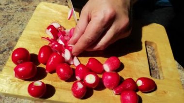 Tahta üzerinde turp kesen bir adamın görüntüsü.