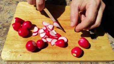 Tahta üzerinde turp kesen bir adamın görüntüsü.