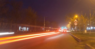 Geceleyin hareket halindeki arabalarla yol. Doğadaki parkta.