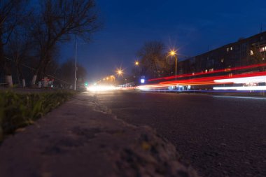 Geceleyin hareket halindeki arabalarla yol. Doğadaki parkta.