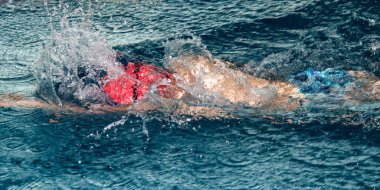 Havuzda yüzen bir çocuğun spor hareketi.