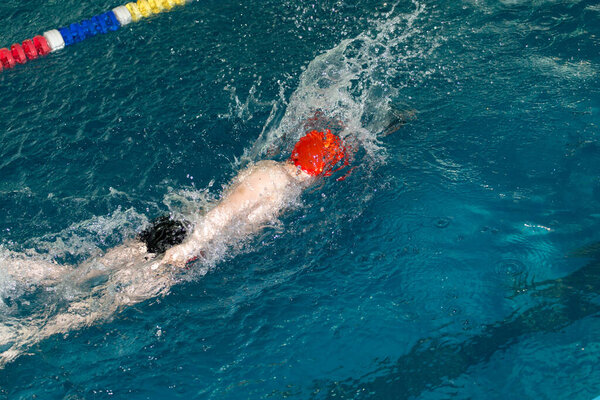 sport motion shot of boy swimming in pool