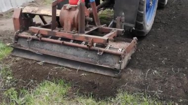 Kasaba bahçesinde traktör ekimi görüntüleri.