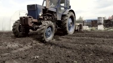 Kasaba bahçesinde traktör ekimi görüntüleri.