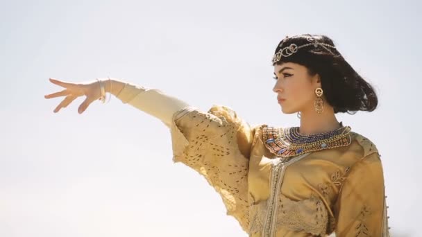 Krásná žena s módní make-up a účes jako egyptská Královna Kleopatra venku proti obloze