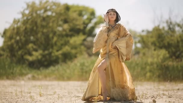 Beautiful woman like Egyptian Queen Cleopatra on in desert outdoor. — Stock Video