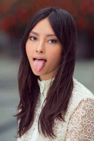 Belle asiatique femme montrant la langue — Photo