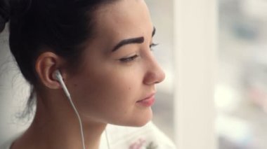 Musik dinleme pencere oturan kulaklıklar çekici genç kadın