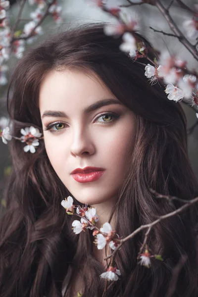 Belle fille debout à l'arbre en fleurs dans le jardin — Photo