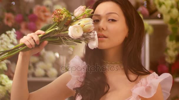 Žena a květiny. Portrét Asijská dívka s kyticí — Stock video