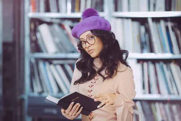 Asyalı öğrenci holding kitap kütüphane — Stok fotoğraf