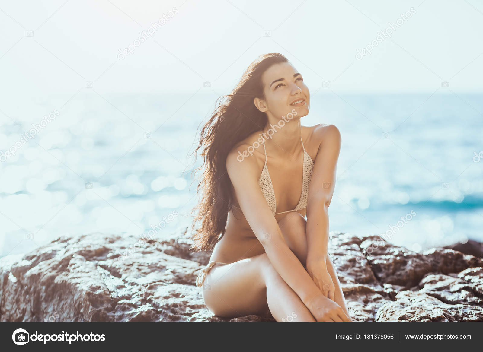 Portrait of beautiful young woman on wild rocky beach photo