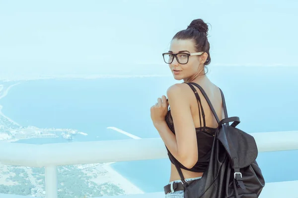 Hermosa joven turista con mochila cerca del mar —  Fotos de Stock