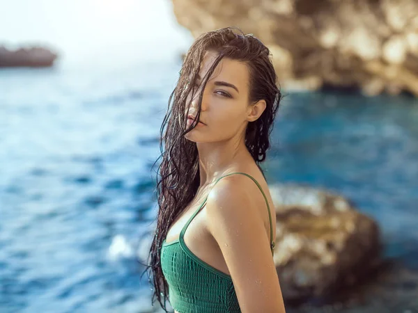 Portret van mooie jonge vrouw op wild rotsachtige strand. — Stockfoto