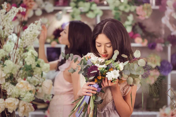 Belles femmes asiatiques fleuristes heureux de travailler dans un magasin de fleurs avec beaucoup de fleurs de printemps — Photo