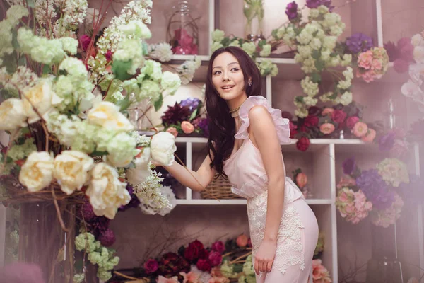 Bella donna asiatica fiorista in abito rosa nel negozio di fiori — Foto Stock