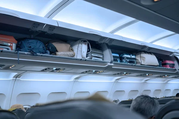 Luggage shelf with luggage in an airplane. Aircraft interior. Travel concept. — Stock Photo, Image