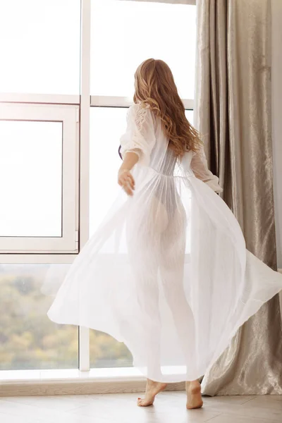 Mooie jonge meisje in een sexy lingerie en witte badjas — Stockfoto