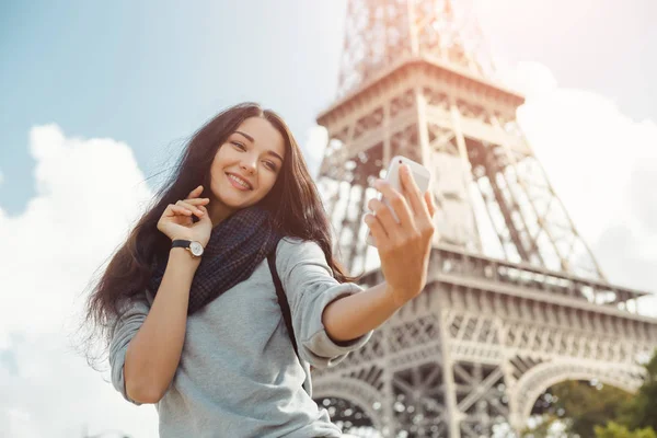 Όμορφη νεαρή κοπέλα που παίρνει αστεία selfie με το κινητό της τηλέφωνο κοντά στον πύργο του Άιφελ. — Φωτογραφία Αρχείου
