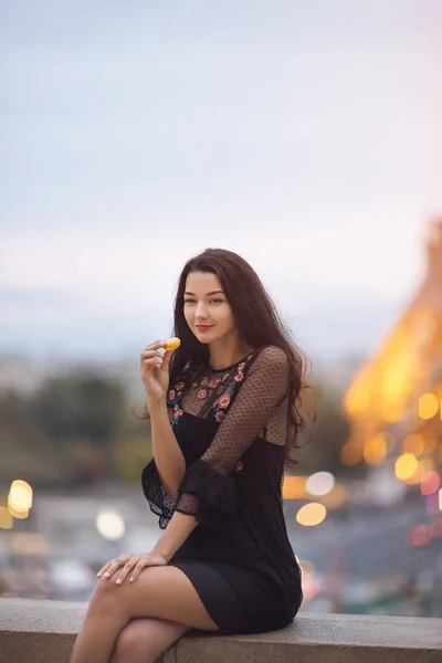 Femme parisienne souriante mangeant le macaron pâtissier français à Paris contre la tour Eiffel. — Photo