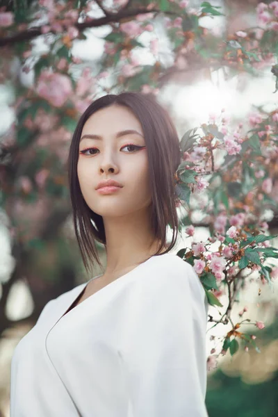Asiática mujer al aire libre en primavera contra flor flor — Foto de Stock