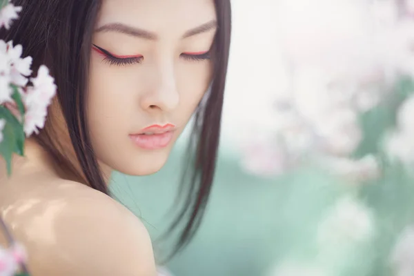 Portrait d'une belle fille asiatique fantaisie en plein air sur fond de fleur de printemps naturel . — Photo