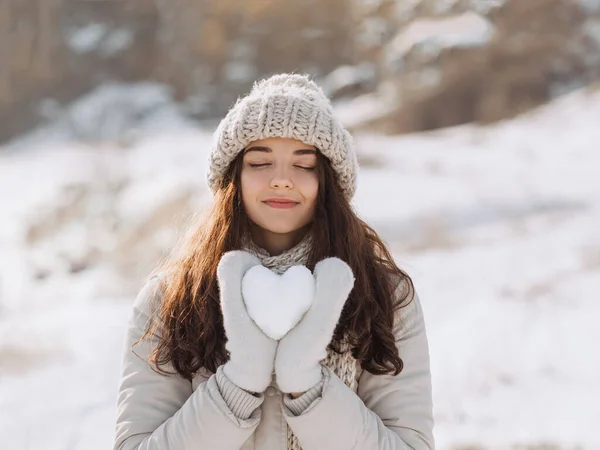 Снежное сердце в руках женщины — стоковое фото