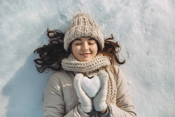 Corazón de nieve en manos de una mujer — Foto de Stock