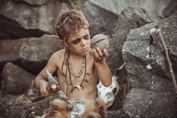 Homem das cavernas, rapaz viril a fazer uma arma de pedra primitiva no acampamento — Fotografia de Stock