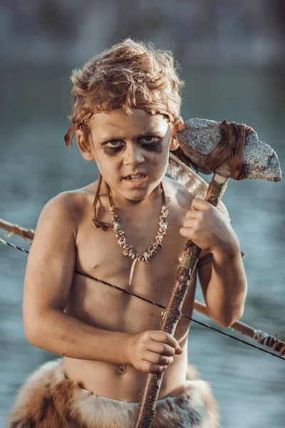 Caveman, manly boy with primitive weapon hunting outdoors. Ancient prehistoric warrior. Heroic movie look — Stock Image Caveman, manly boy with primitive weapon hunting outdoors. Ancient prehistoric warrior. Heroic movie look Stock Image