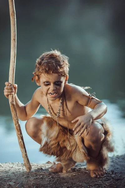 Angry caveman, manly boy with staff hunting outdoors. Ancient warrior — Stock Image Angry caveman, manly boy with staff hunting outdoors. Ancient warrior Stock Image
