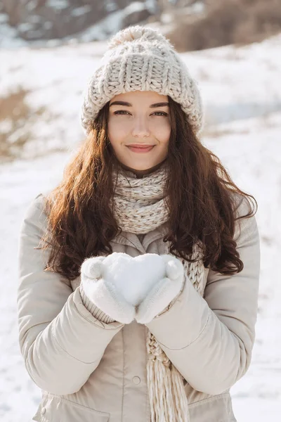 Snö hjärta i händerna på en kvinna — Stockfoto