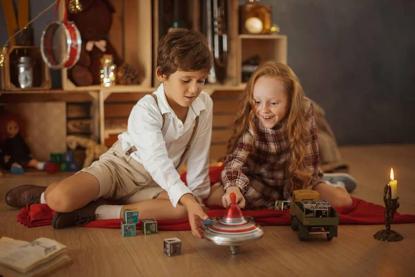 Duas crianças brincando com brinquedos perto da árvore de Natal — Fotografia de Stock